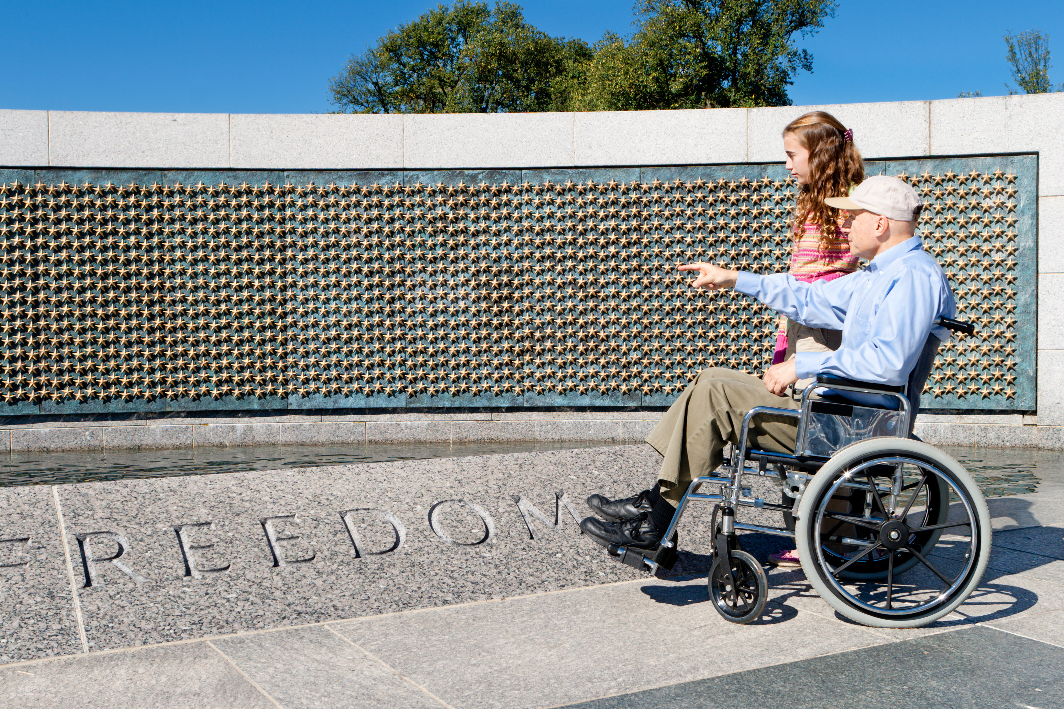veteran at war memorial with child